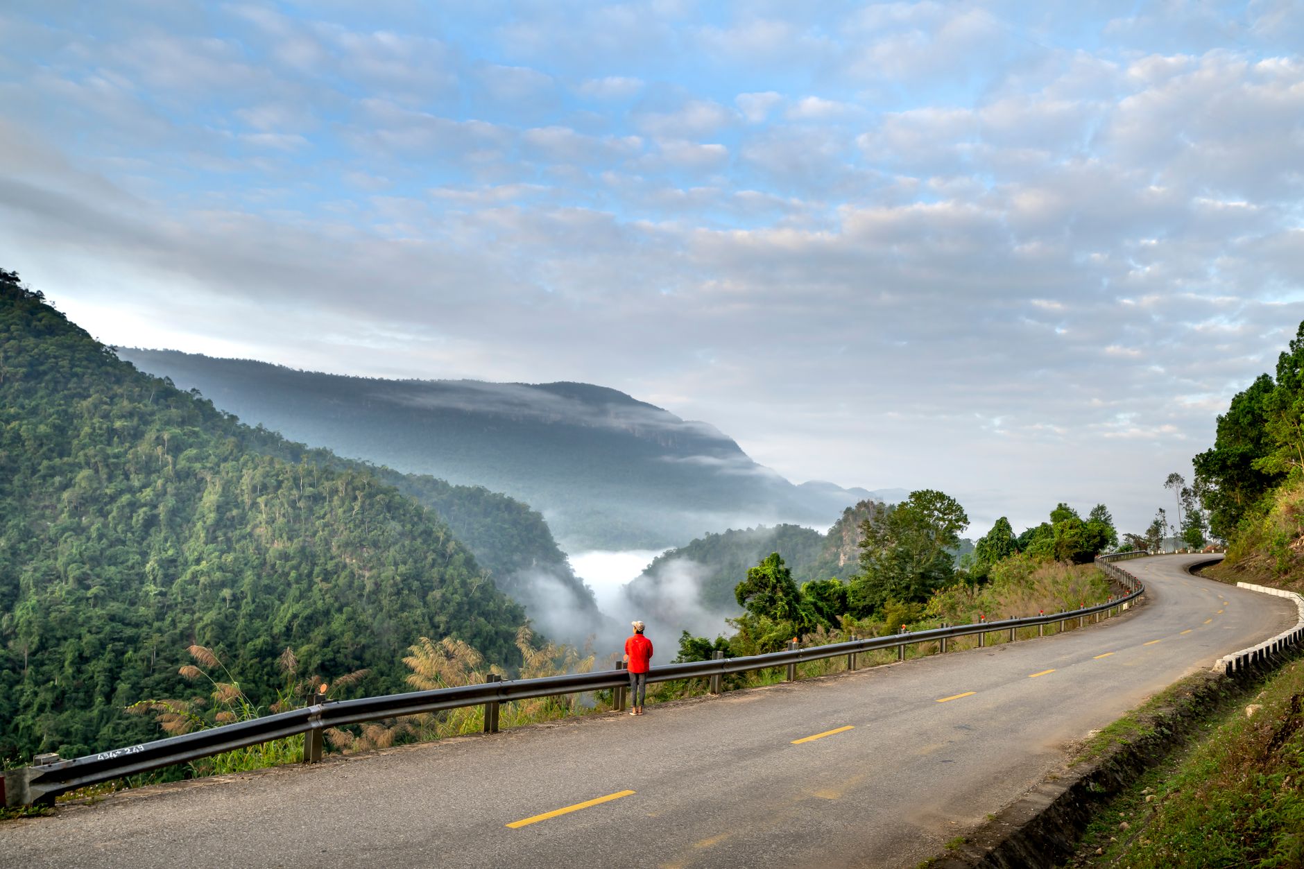 Travel writer taking notes in misty morning valley