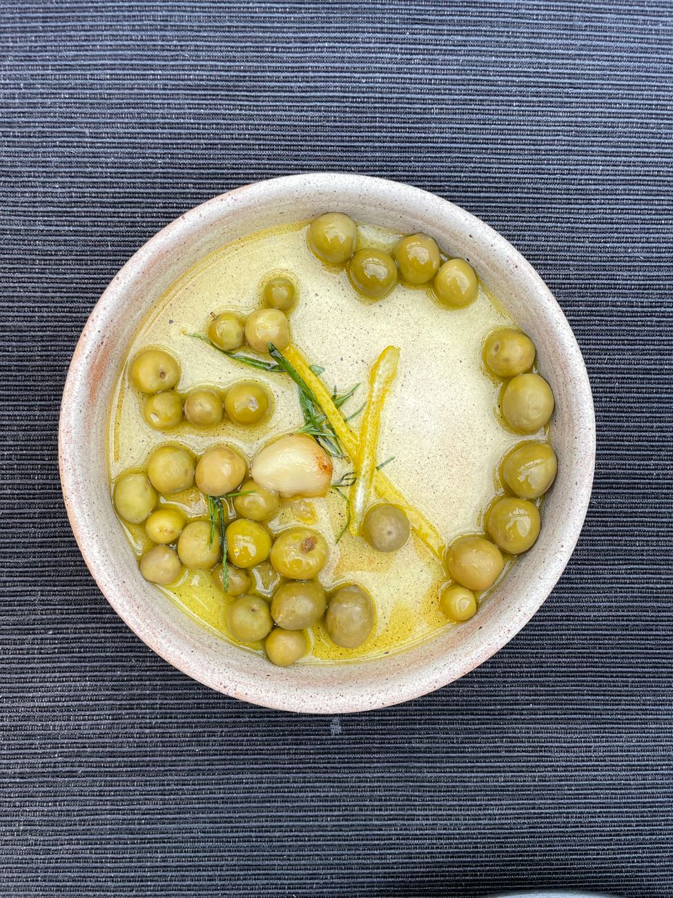 Earthen bowls filled with wild herbs and olive oil on rustic wooden table